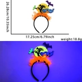 Dettaglio del cerchietto neon per Halloween con pipistrello e scritte Boo sotto luce viola - Stile luna e albero morto