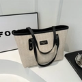 Straw tote bag with black faux leather trim and brand label for daily fashion - Black