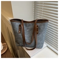 Detail of large grey tote bag with brown leather handles and decorative rivets - Blue