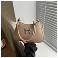 Detail of beige shoulder bag featuring silver metal bow and rounded tube handles - Khaki