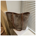 Close-up of vintage brown canvas tote bag with leather trim and gold metal rivets - Dark Brown