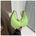 Detail view of bright green crescent moon bag with silver buckle and smooth leather texture - Green