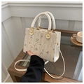 Cream straw crossbody bag featuring delicate floral embroidery and a white round handle - Off-white Green Floral
