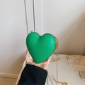 Detail of green heart-shaped hard shell clutch with gold metal trim and chain strap - Green