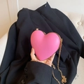 Detail of pink heart-shaped hard shell clutch bag with gold chain and metal clasp - Pink