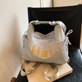 Detail of light blue nylon tote bag with yellow Hai embroidery and drawstring side ties - Gray