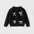 Detail of black knit cardigan featuring elegant white bow ties and fine ribbed cuffs - 90cm / Tops / Black
