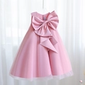 Dettaglio dell'elegante abito rosa cipria da bambina con grande fiocco in raso e gonna in tulle - 100cm / Rosa