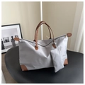 Detail der grauen Nylon-Reisetasche mit braunen Ledergriffen und kleinem Täschchen - Grau