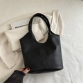 Minimalist black pebbled leather tote bag featuring a vertical seam and bucket silhouette - Black