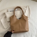 Minimalist caramel brown leather tote bag with lychee texture and wavy handle detail - Khaki