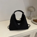 Sac bandoulière en nylon noir avec chaîne argentée et logo sur un bureau minimaliste - Avec Pendentif / Noir