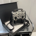 Modischer Mini-Rucksack mit Leopardenmuster, schwarzen Einsätzen und Goldschnallen - Schwarz