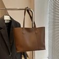 Retro bruine leren draagtas met lange banden getoond in een stijlvolle lifestyle-omgeving - Donkerbruin
