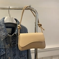 Borsa sottospalla beige minimalista con tracolla a nodo su sfondo denim blu scuro - Cachi
