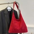Minimalist red suede tote bag with wide shoulder strap displayed on a stand - Red
