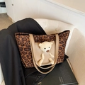 Borsa tote leopardata con orsetto di peluche 3D e manici in pelle marrone sulla sedia - Marrone
