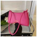 Detail der leuchtend rosa Schultertasche mit gelbem Fashion-Schriftzug in Lifestyle-Optik - Rosarot