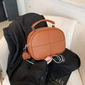 Brown litchi grain leather crossbody pillow bag with black stitching and striped strap - Brown