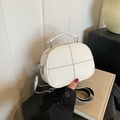 White minimalist pillow bag with black cross stitching and striped shoulder strap - White