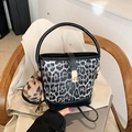 Fashionable leopard print bucket bag with black leather handle and plush pom-pom charm - With Pendant / Black