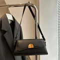 Minimalist black leather shoulder bag with stylish wave flap and gold buckle detail - Black