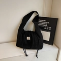 Black corduroy drawstring bucket bag for women with a stylish minimalist white woven label - Black