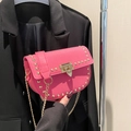 Bolso bandolera rosa con textura de lichi, remaches dorados y cadena fina - Rosa