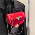 Bolso de hombro rojo de cuero con tachuelas doradas y correa de cadena metálica - Rojo