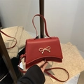 Crossbody square bag in bright red faux leather featuring a golden metal bow buckle - Red