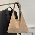 Elegante bolso tote de ante beige con correa de cuero marrón en un perchero de ropa - Caqui