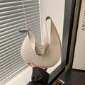 Sac à main croissant blanc crème chic avec texture tissée tenu devant un décor minimaliste - Motif Tressé / Blanc