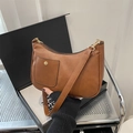 Caramel brown crescent shoulder bag with golden round buckle and leather texture - Brown