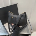 Minimalist black crescent shoulder bag in PU leather with gold hardware and front pocket - Black