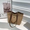 Retro-Tragetasche in Khaki mit dunkelbraunen Riemen und Vordertasche auf weißem Sockel - Khaki