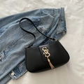 Black minimalist underarm bag in matte leather featuring a gold tassel and SS logo - Black