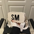 Cream square crossbody bag with black SM letter design and wide woven shoulder strap - White