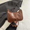 Chic caramel brown croissant-shaped underarm bag with unique knotted strap and gold foil text - Brown