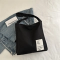 Minimalistische schwarze Canvas-Tasche mit Retro-Text-Patch und verstellbarem Gurt - Schwarz