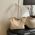 Minimalistische beige Tragetasche mit Webstruktur und Doppelriemen auf Kunstbüchern - Gebrochenes Weiß