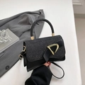 Borsa a tracolla nera glitterata con fibbia a D dorata su una superficie bianca - Nero