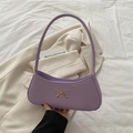 Bolso de hombro lavanda minimalista con lazo dorado sobre un blazer color crema - Morado