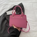 Chic pink leather handbag with knot handles and crossbody strap for spring 2025 - Pink