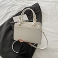 Chic white leather handbag with knot handles and shoulder strap in casual setting - White