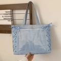 Light blue nylon tote bag with transparent PVC pocket and ribbon bows in studio setting - Blue