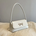 Chic cream-white baguette bag with golden bow accent and long shoulder strap - Off White