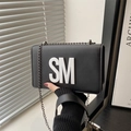 Minimalist black faux leather crossbody bag with white SM letter accent and chain strap - Black