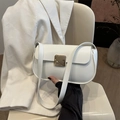 Elegante bolso de hombro de cuero blanco con broche dorado en un ambiente francés chic - Blanco