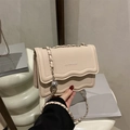 Chic cream-colored chain crossbody bag with pebble leather and wave-edge flap - Khaki