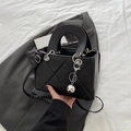 Classic black quilted square handbag with a silver mirror ball charm and dual handles - Black